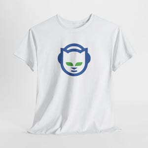 May include: White t-shirt with a blue and green graphic of a cat-like face wearing headphones. The design is centrally placed. The t-shirt is made of a soft, lightweight material.