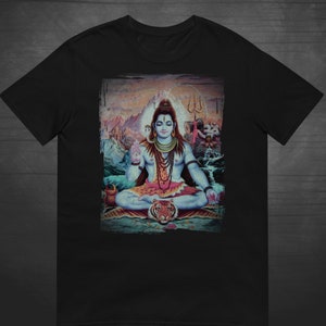 Könnte beinhalten: Ein schwarzes T-Shirt mit einem farbenfrohen Bild von Shiva, einer hinduistischen Gottheit, der in meditativer Haltung mit einem Tiger zu seinen Füßen sitzt. Das Bild ist von einem verblassten, abgenutzten Rahmen umgeben.