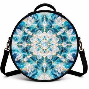 May include: A round bag with a black frame and strap featuring a vibrant blue and white mandala pattern. The design includes intricate geometric lines, sparkling crystal-like shapes, and swirling water-like textures centered around a bright gem.