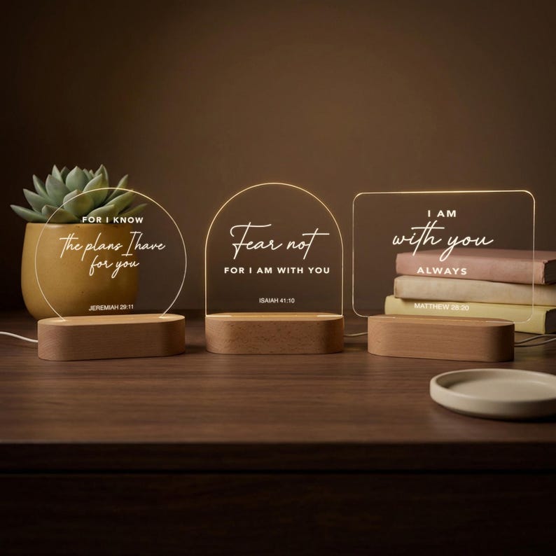 May include: Three illuminated acrylic signs with wooden bases. The signs display inspirational quotes: "For I know the plans I have for you," "Fear not, for I am with you," and "I am with you always."