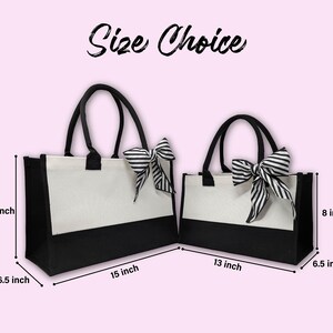 K&ouml;nnte beinhalten: Zwei Einkaufstaschen mit schwarz-wei&szlig;en gestreiften Schleifen. Die gr&ouml;&szlig;ere Tasche ist 38 cm breit, 25 cm hoch und 16 cm tief. Die kleinere Tasche ist 33 cm breit, 20 cm hoch und 16 cm tief.