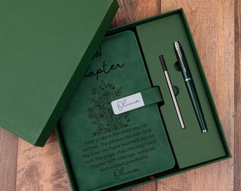 Könnte beinhalten: Eine dunkelgrüne Geschenkbox mit einem passenden grünen Notizbuch und Stift. Der Einband des Notizbuchs zeigt eine Blumenillustration, den Text "New Chapter" und den Namen "Olivia" auf einer Lasche. Der Text lautet "Take pride in the story you've written."