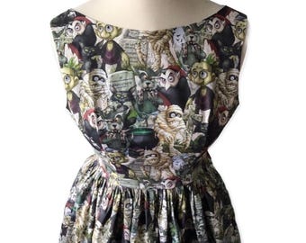 May include: A sleeveless dress with a black background and a colorful print of various monsters, including a werewolf, a mummy, a vampire, and a Frankenstein's monster.