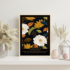 May include: Framed art print featuring a floral pattern with white and yellow flowers, green and orange leaves, and a dark blue background. The print includes the text "Andrew Murray" and a quote about humility.