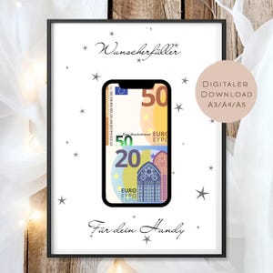 Op de afbeelding: Een ingelijste print met een zwarte rand toont een smartphone-afbeelding met eurobiljetten. De print bevat de tekst "Wunscherfüller" en "Für dein Handy", samen met steraccenten. Een digitale download is aangegeven.