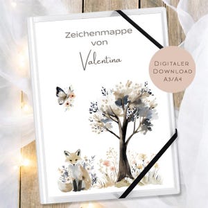 May include: White art portfolio with a watercolor illustration of a fox, tree, and butterfly. The text "Zeichenmappe von Valentina" is at the top. A black elastic band secures the portfolio. A digital download is available.