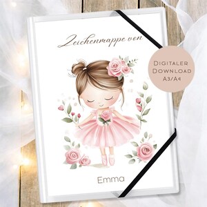 May include: A white art portfolio with a ballerina illustration. The ballerina wears a pink dress and has a flower in her hair. The portfolio has the text "Zeichenmappe von" and "Emma". A black elastic band secures the portfolio.
