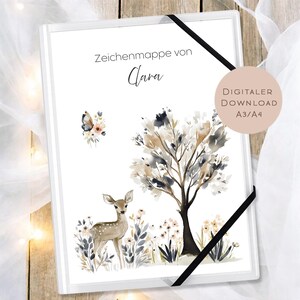 May include: White art portfolio with a watercolor illustration of a deer, tree, and butterfly. The portfolio has the text "Zeichenmappe von Clara" and a black elastic band closure. A digital download is available in A3/A4 sizes.