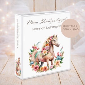 Puede incluir: Una carpeta blanca con el texto "Meine Kindergartenzeit Hannah Lehmann" y una ilustración de acuarela de un caballo adornado con flores. También se ven las palabras "DIGITALER DOWNLOAD".