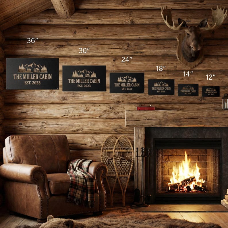 May include: Black metal signs with mountain silhouettes and the text "THE MILLER CABIN EST. 2023" in various sizes: 36", 30", 24", 18", 14", and 12". The signs are displayed on a rustic wooden wall, with a cozy cabin interior setting.