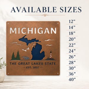 May include: A square copper-toned metal wall sign featuring a cutout map of Michigan, the text "MICHIGAN THE GREAT LAKES STATE EST. 1837", green pine trees, and a red and white lighthouse. A list of available sizes from 12" to 40" is displayed.
