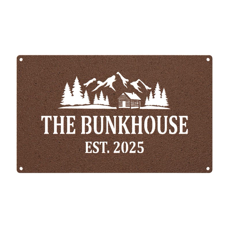 May include: A rectangular brown metal sign with the words "THE BUNKHOUSE EST. 2025" in white. The sign features a white graphic of mountains, trees, and a cabin. Four small holes are in each corner.