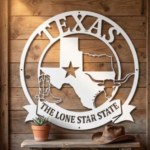 Pu&ograve; includere: Un'insegna in metallo bianco raffigurante lo stato del Texas, una stella, uno stivale da cowboy e un longhorn. L'insegna &egrave; circolare con la scritta "TEXAS" in alto e "THE LONE STAR STATE" su uno stendardo sottostante. Una piccola pianta in vaso e un cappello da cowboy sono su una mensola di legno.