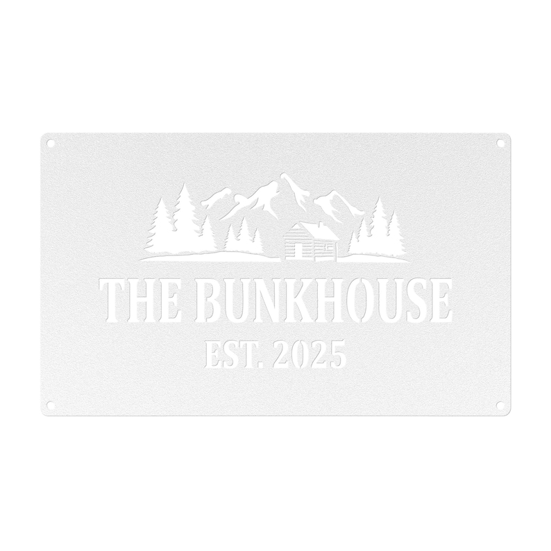 May include: A white metal sign with the words "THE BUNKHOUSE" and "EST. 2025" in a sans-serif font. The sign features a mountain and cabin scene. The sign has four small holes, one in each corner.