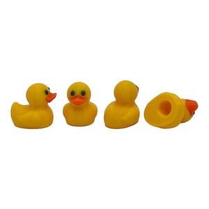 Puede incluir: Cuatro patos de goma amarillos en diferentes poses. Los patos tienen ojos negros y picos naranjas.