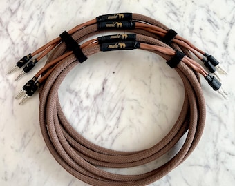 May include: Brown audio cables with black connectors and a woven texture. The cables are bundled with black velcro straps. The brand name "mule" is printed on the cables.