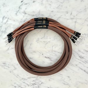 May include: A close-up of a brown braided cable with multiple connectors. The cable is labelled "mule" in gold lettering.