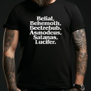 Könnte beinhalten: Schwarzes T-Shirt mit weißem Text, der "Belial, Behemoth, Beelzebub, Asmodeus, Satanas, Lucifer." lautet.