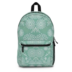 Puede incluir: Una mochila azul verdosa con un patrón floral blanco. La mochila tiene un bolsillo con cremallera en la parte delantera y dos correas ajustables.