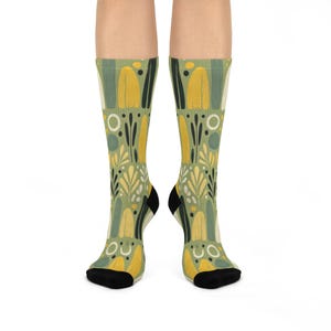 May include: A pair of green socks with a yellow and green abstract floral pattern.