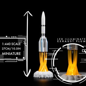 May include: Miniature rocket model, 10.5 inches tall, with LED illuminated exhaust plume. The rocket is white and silver with a white base. The image includes the text "1:440 SCALE 27CM/10.5IN MINIATURE" and "LED ILLUMINATED EXHAUST PLUME".