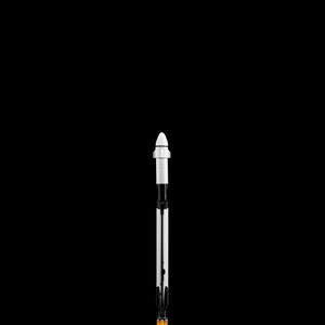 May include: A miniature rocket model against a black background. The rocket has a white nose cone, a black and white body, and an orange and white base, suggesting flames. The design is detailed and stylized.