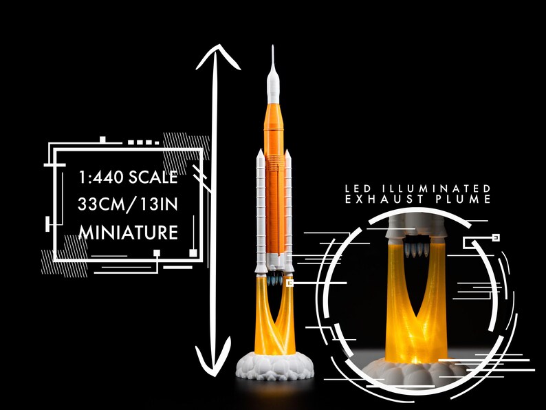 May include: A miniature rocket model, 33cm tall, with orange and white detailing. The model features an LED illuminated exhaust plume and is labeled as 1:440 scale. The miniature sits on a white cloud-like base against a black background.