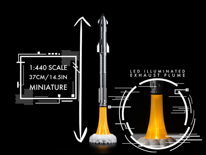 May include: A miniature silver and white rocket model with an LED illuminated exhaust plume. The model is 14.5 inches tall and is labeled as 1:440 scale. The rocket is set against a black background.