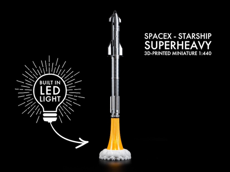 May include: A 3D-printed miniature of the SpaceX Starship Superheavy rocket, scale 1:440. The silver and black rocket has a yellow flame effect at the base, with a white cloud of smoke. The model has a built-in LED light.