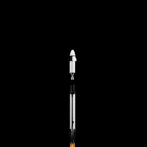May include: A model rocket against a black background. The rocket is white and black with an orange base and a white cloud-like structure at the bottom. The rocket is standing upright.