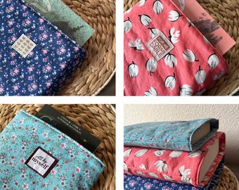 May include: Three book covers made of fabric with floral patterns. The covers are blue, pink, and turquoise. The covers have the titles "La Passe-Miroir", "For the Dable", and "All by myself" printed on them.