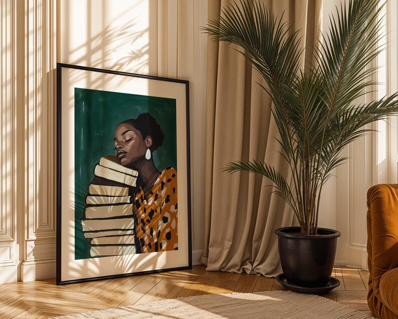 May include: Framed art print featuring a woman with closed eyes, resting against a stack of books. The artwork has a dark green background and the woman is wearing a patterned orange and black top. The print is in a black frame.