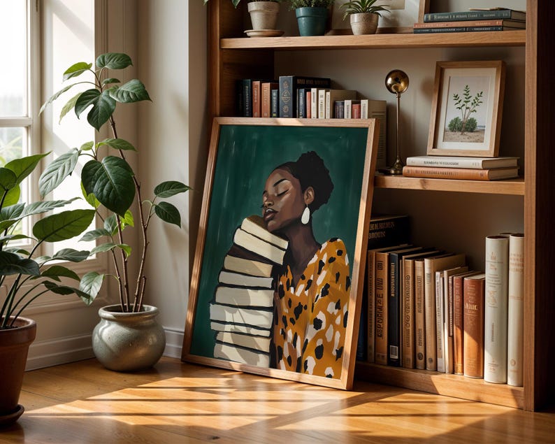 May include: A framed art print featuring a woman with a stack of books, set against a green background. The woman wears a yellow and brown patterned top and large white earrings. The artwork is displayed on a wooden bookshelf with other books and decorative items.
