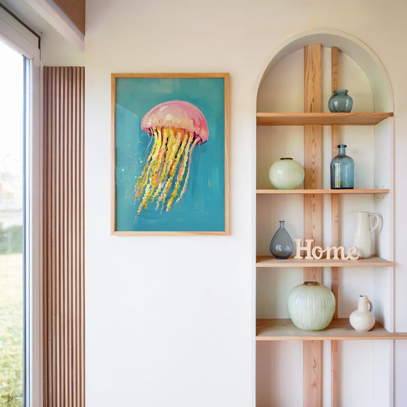 K&ouml;nnte beinhalten: Gerahmtes Gem&auml;lde einer Qualle mit rosa Glocke und gelben Tentakeln vor t&uuml;rkisfarbenem Hintergrund. Das Kunstwerk h&auml;ngt an einer wei&szlig;en Wand in der N&auml;he eines Fensters und eines Holzregals mit dekorativen Vasen und einem "Home"-Schild.