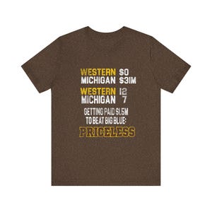 Könnte beinhalten: Ein braunes Kurzarm-T-Shirt mit weißem und gelbem Text: WESTERN $0, MICHIGAN $3M, WESTERN 12, MICHIGAN 7, GETTING PAID $1.5M TO BEAT BIG BLUE: PRICELESS. Das T-Shirt hat einen Rundhalsausschnitt und eine melierte Stoffstruktur.
