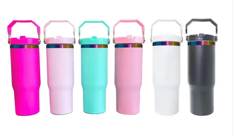 Puede incluir: Seis vasos de viaje de acero inoxidable con asas y tapas. Los vasos son de varios colores: rosa, azul claro, blanco, negro y dos tonos de rosa.