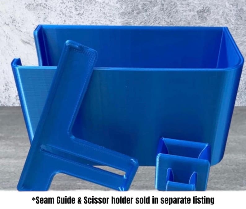 Op de afbeelding: Een set blauwe plastic naaiorganizers. De set bevat een grote rechthoekige bak, een kleinere vierkante container en een L-vormige naadgeleider. De tekst onderaan luidt "Seam Guide & Scissor holder sold in separate listing."