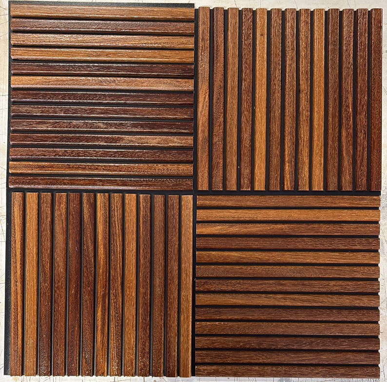 Op de afbeelding: Een vierkante houten tegel verdeeld in vier secties. Elke sectie toont een ander patroon van donkerbruine houten latten, horizontaal of verticaal gerangschikt, waardoor een textuur ontstaat. Het hout heeft een natuurlijke nerf en een warme kleur.