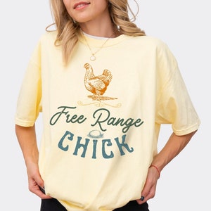 May include: A yellow t-shirt with a drawing of a chicken and the text "Free Range Chick" in blue and green.