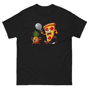 Op de afbeelding: Een zwart T-shirt met een cartoon afbeelding van een pizzapunt dat een pizzames houdt en een huilende ananas achtervolgt.