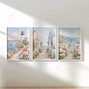 May include: A triptych of coastal landscape paintings featuring a white lighthouse, pastel-colored cottages, and blooming pink hydrangea bushes along a stone path. The scenes include sailboats on the water, white picket fences, and blue skies.