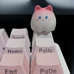 May include: Pink and white cat-shaped keycap with blue eyes and a white keyboard with pink keys labeled 'Home', 'End', 'PgUp', 'PgDn', and 'Scroll'.