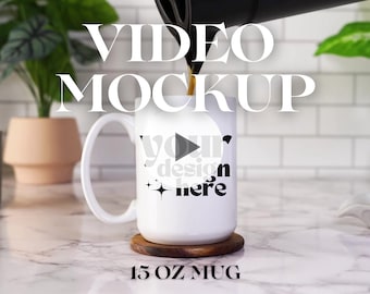 May include: White ceramic mug with a black play button and the text "your design here" on the front. The mug is being filled with coffee and is sitting on a wooden coaster. The text "15 oz MUG" is below the mug.