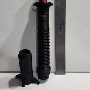 May include: A black and red lightsaber prop with a ribbed handle and a red blade. The lightsaber is 11 inches long and is made of plastic. The lightsaber is a popular collectible for fans of the Star Wars franchise.