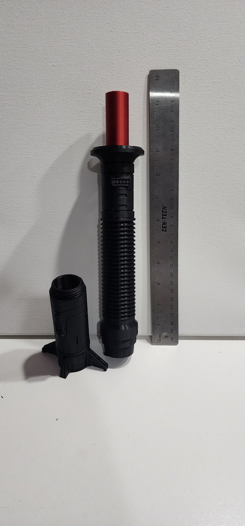 May include: A black and red lightsaber prop with a ribbed handle and a red blade. The lightsaber is 11 inches long and is made of plastic. The lightsaber is a popular collectible for fans of the Star Wars franchise.