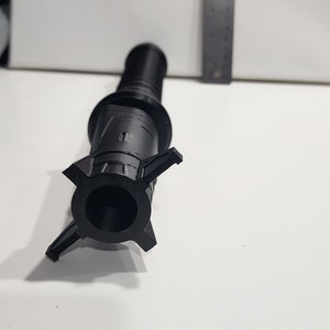 May include: A black plastic 3D printed object with a cylindrical body and a five-pointed star-shaped base.