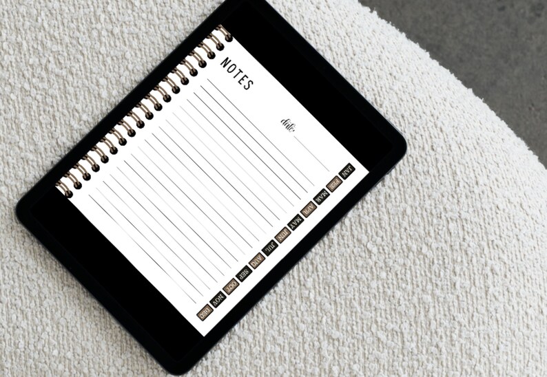 May include: A black and white spiral notebook with the word "NOTES" at the top. The notebook has a date field and a row of small labels along the bottom edge, including "DEC", "NOV", "OCT", "SEP", "AUG", "JUL", "JUN", "MAY", "APR", "MAR", "FEB", and "JAN".