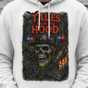 以下が含まれることがあります： 「TALES FROM THE HOOD」の文字が入ったグラフィックデザインの白いパーカー。デザインには、帽子をかぶった骸骨、緑色のスライム、ろうそく、建物、コウモリが含まれています。パーカーにはドローストリングフードが付いています。