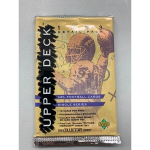 May include: A yellow and black Upper Deck 1993 NFL Football Cards pack. The front of the pack features a cartoon illustration of a football player in a yellow jersey with a football in his hand. The text on the pack reads "Upper Deck", "1993", "Retail Pack", "NFL Football Cards", "Single Series", "12 Cards Per Pack", "Holographically Enhanced", "Collect the "Pro Bowl" 20-Card Insert Set", "Find the 10-Card "Future Heroes" Insert Set", "The Collector's Choice".