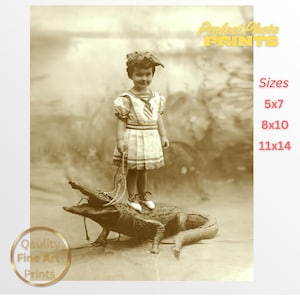 May include: Sepia-toned vintage print featuring a young child in a sailor-style dress and hat, standing atop a large alligator. The child holds a rope, and the image has text that reads "Perfect Photo PRINTS" and "Quality Fine Art Prints."